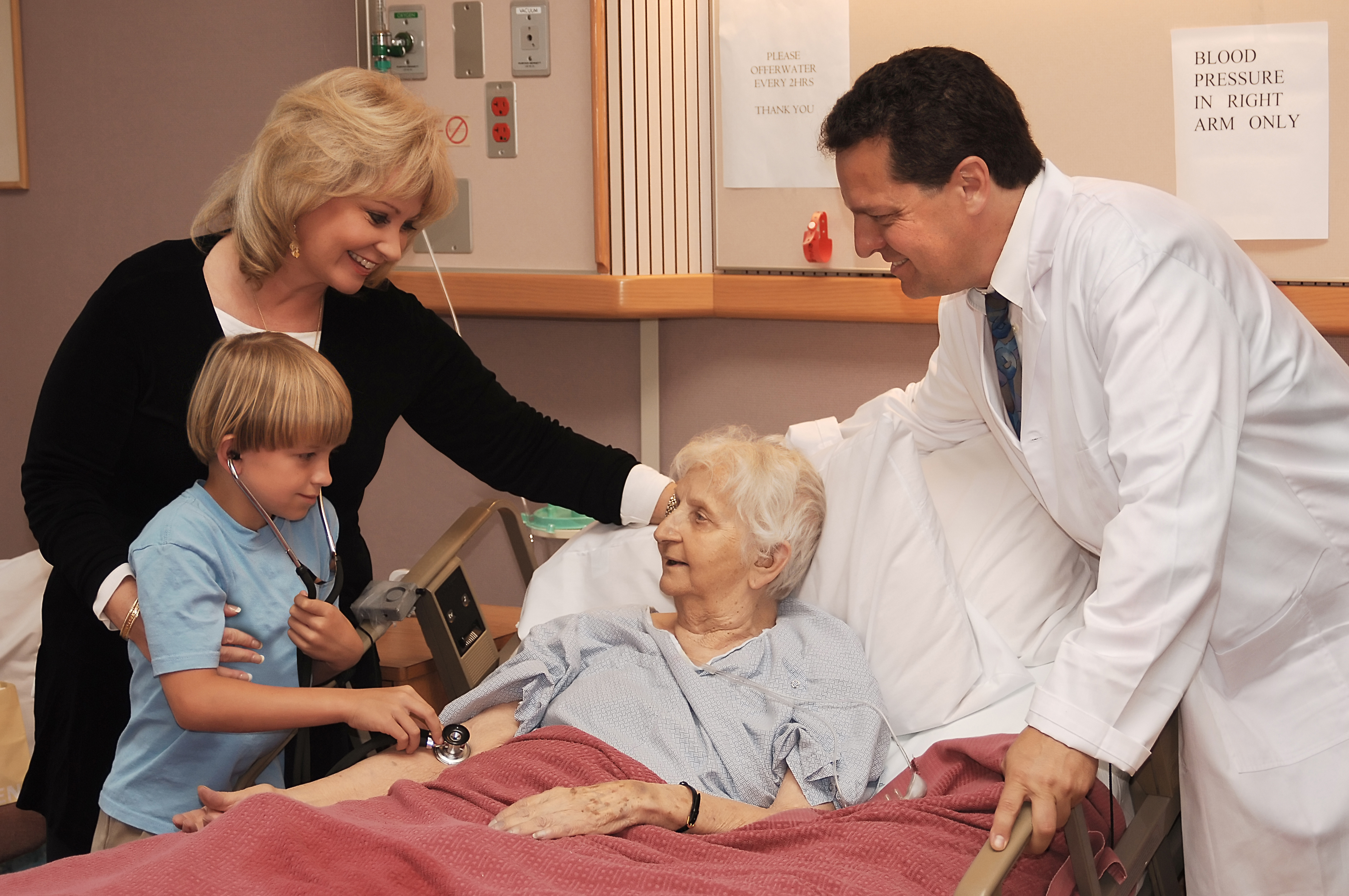 mother, son and doctor visiting grandmother in nursing home