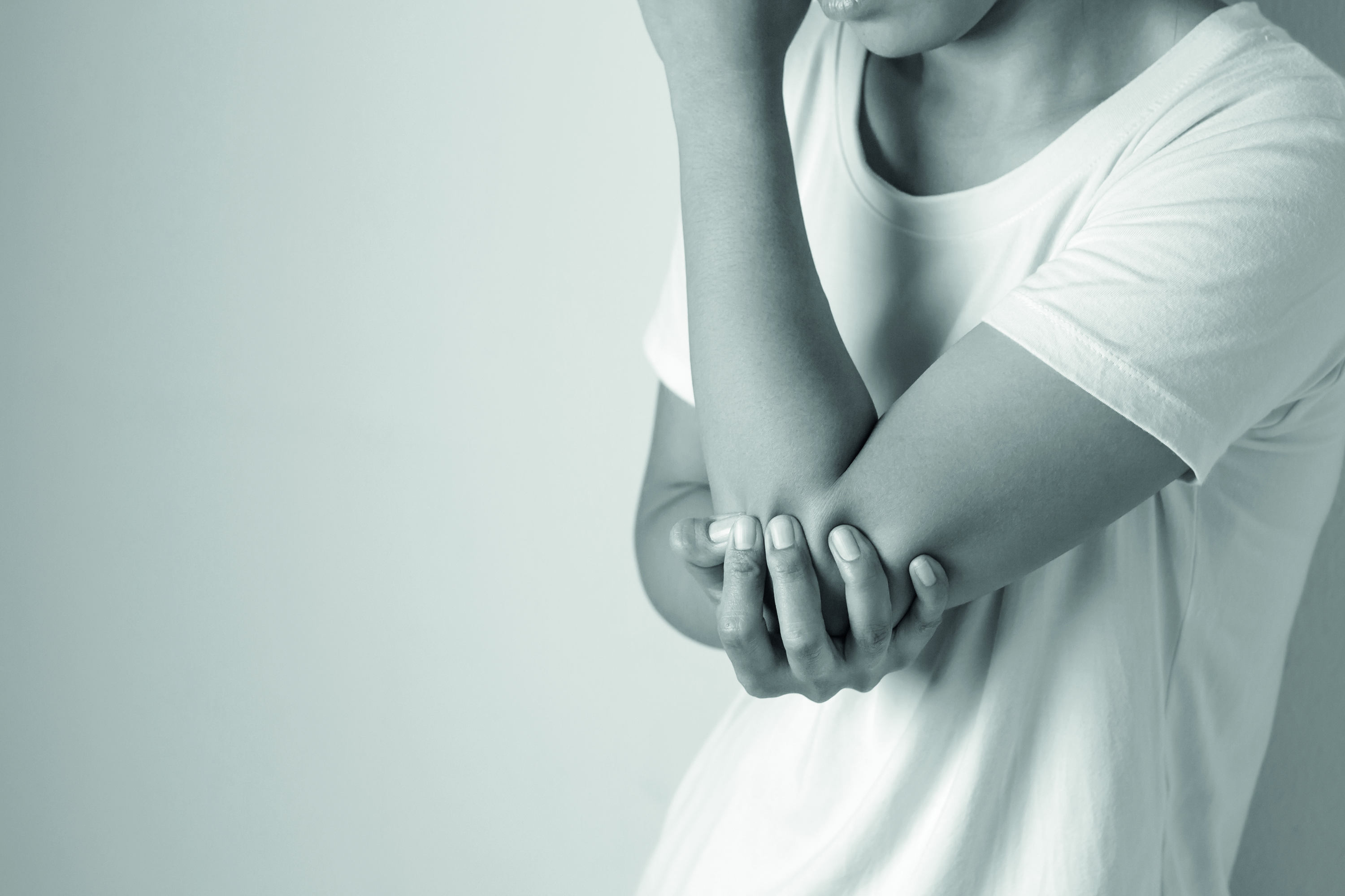 Women with pain in elbow. Acute pain in a elbow. Young woman holds on to elbow