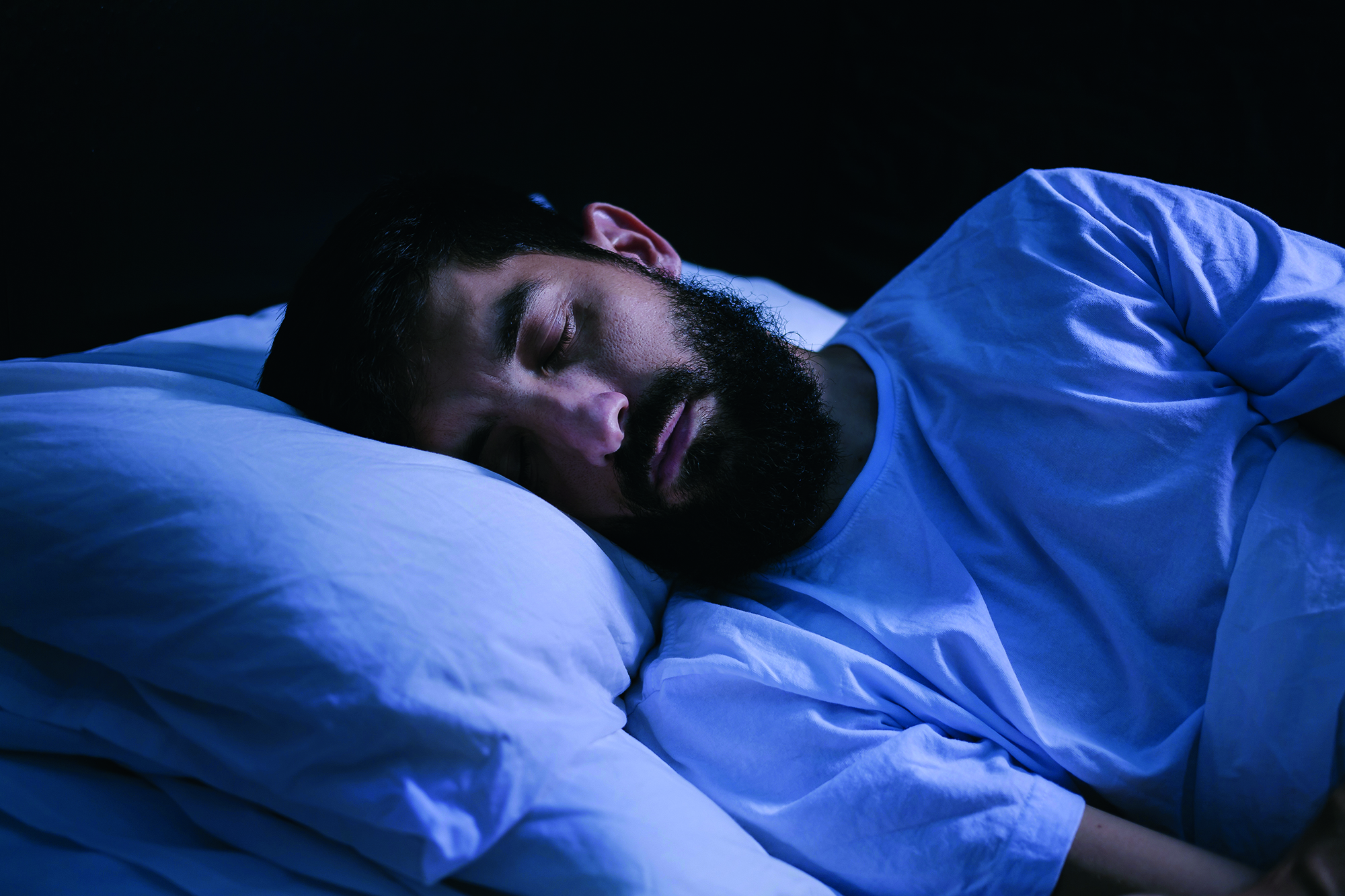 Portrait of a man sleeping in the bed at home