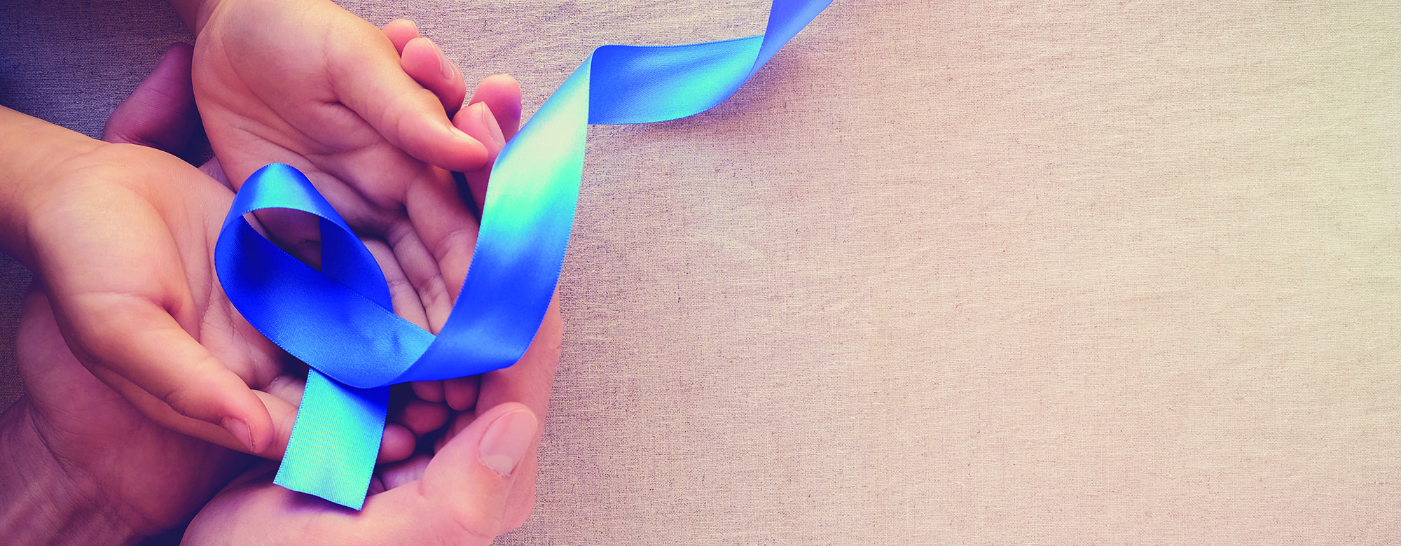 adult and child hands holding Blue ribbon, Colon Cancer, Colorectal Cancer, Child Abuse awareness, world diabetes day