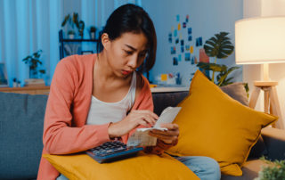 Asian lady feel stress and worried with bill and invoice credit card calculating loan on sofa at home. Home loan stress, Get loan no job,  Coronavirus hardship loans, Can't make loan payment concept.